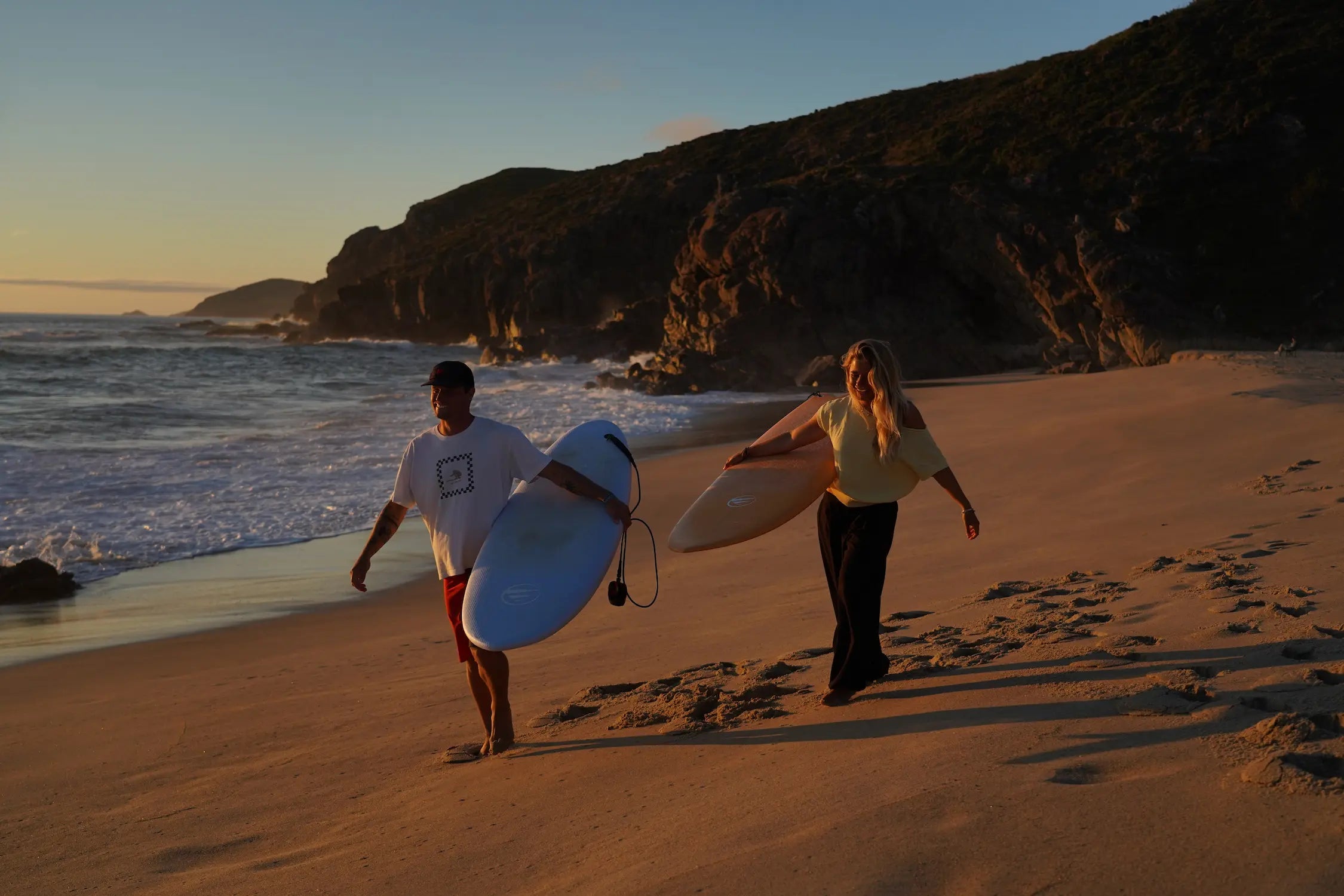 Gina y Uri en la playa en el sunset con las tablas de surf de flysurf.