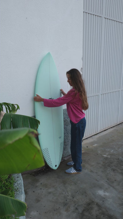 chica colocando la tabla de surf de fibra nueva de flysurf sobre la pared