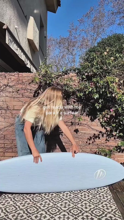 Preparándose para surfear con una tabla shortboard de corcho azul. 