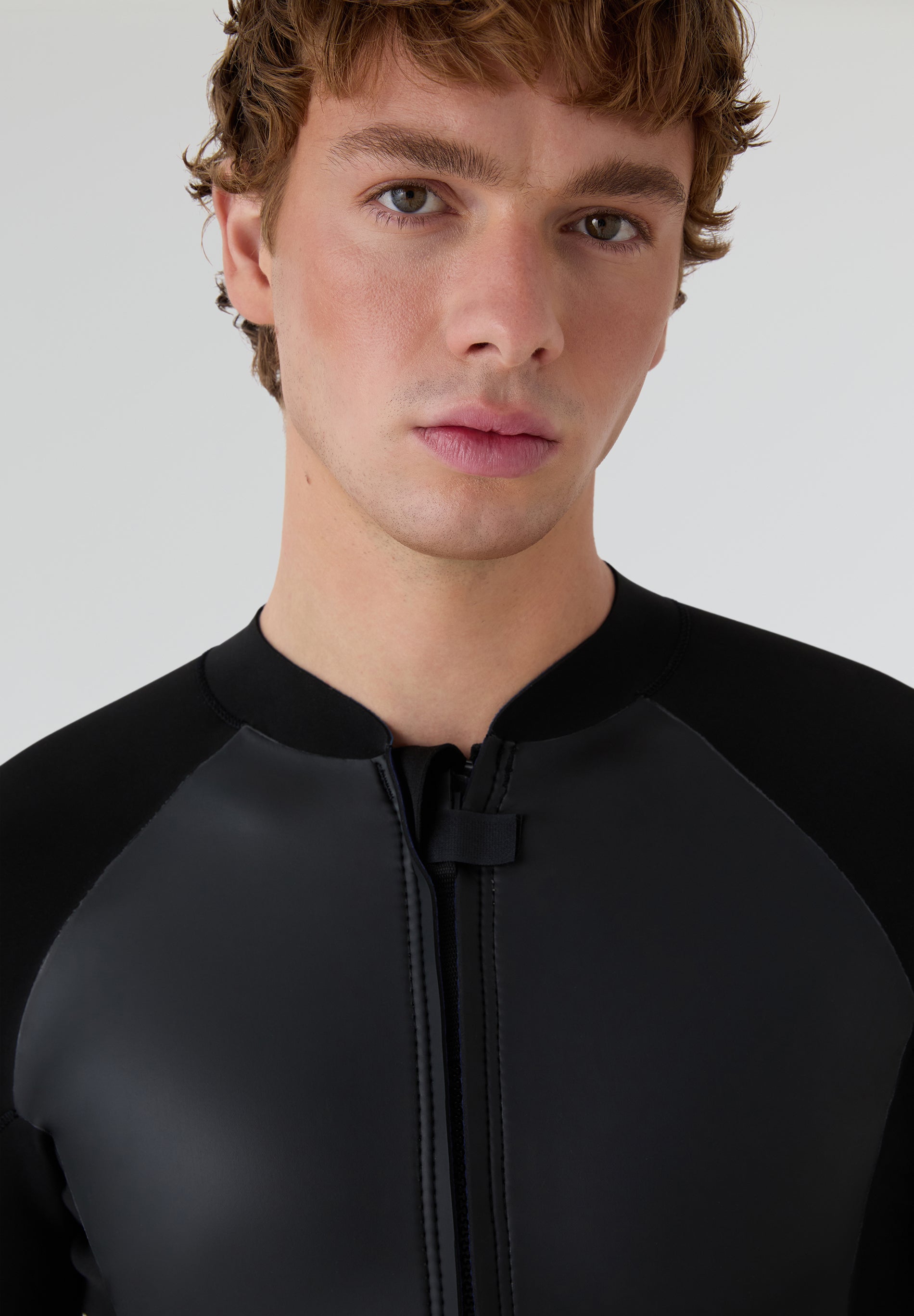 Primer plano frontal del modelo con la camiseta técnica de neopreno diseñada para deportes acuáticos en climas templados.
