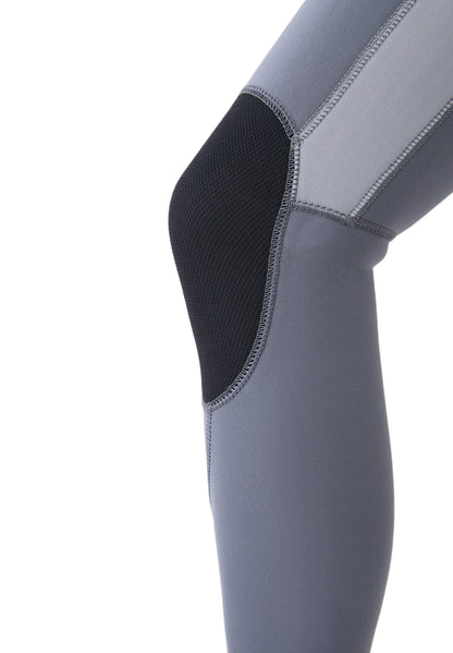 Detalle de las rodilleras protectoras de color negro sobre el neopreno gris, diseñadas para resistir el desgaste del surf.