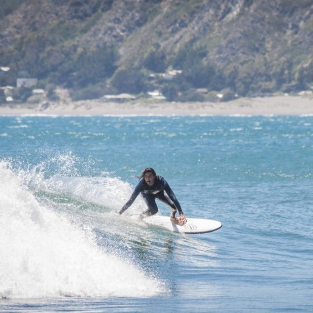 Surfista surfeando una ola con una tabla evolutiva de Flysurf