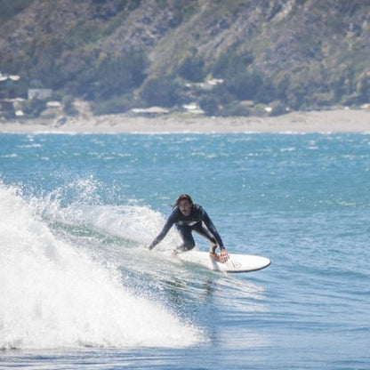 Surfista en la playa surfeando una ola con su tabla de surf evolutiva flysurf