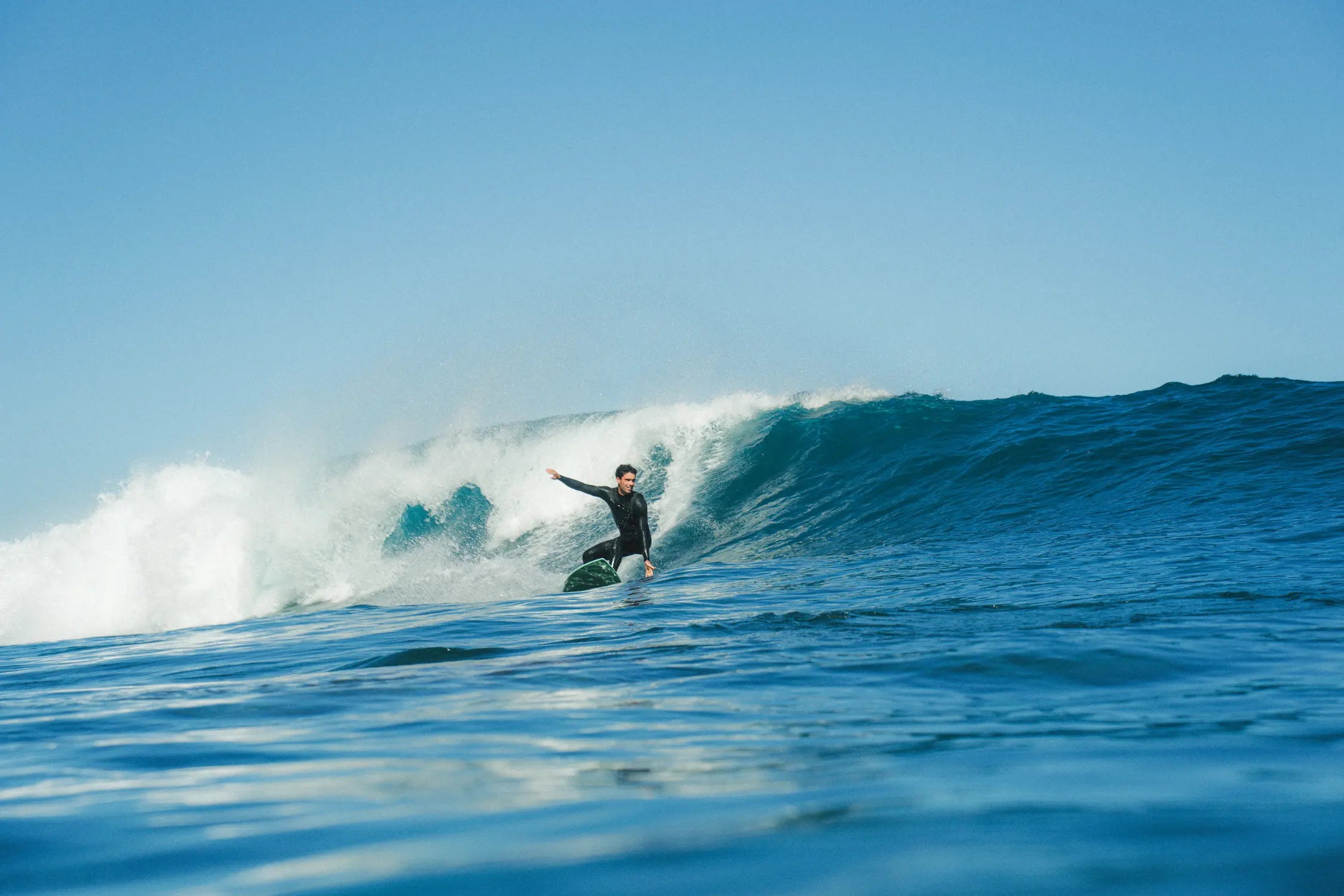 Surfeando una ola con la tabla de surf fibra Apollo 6.4 verde