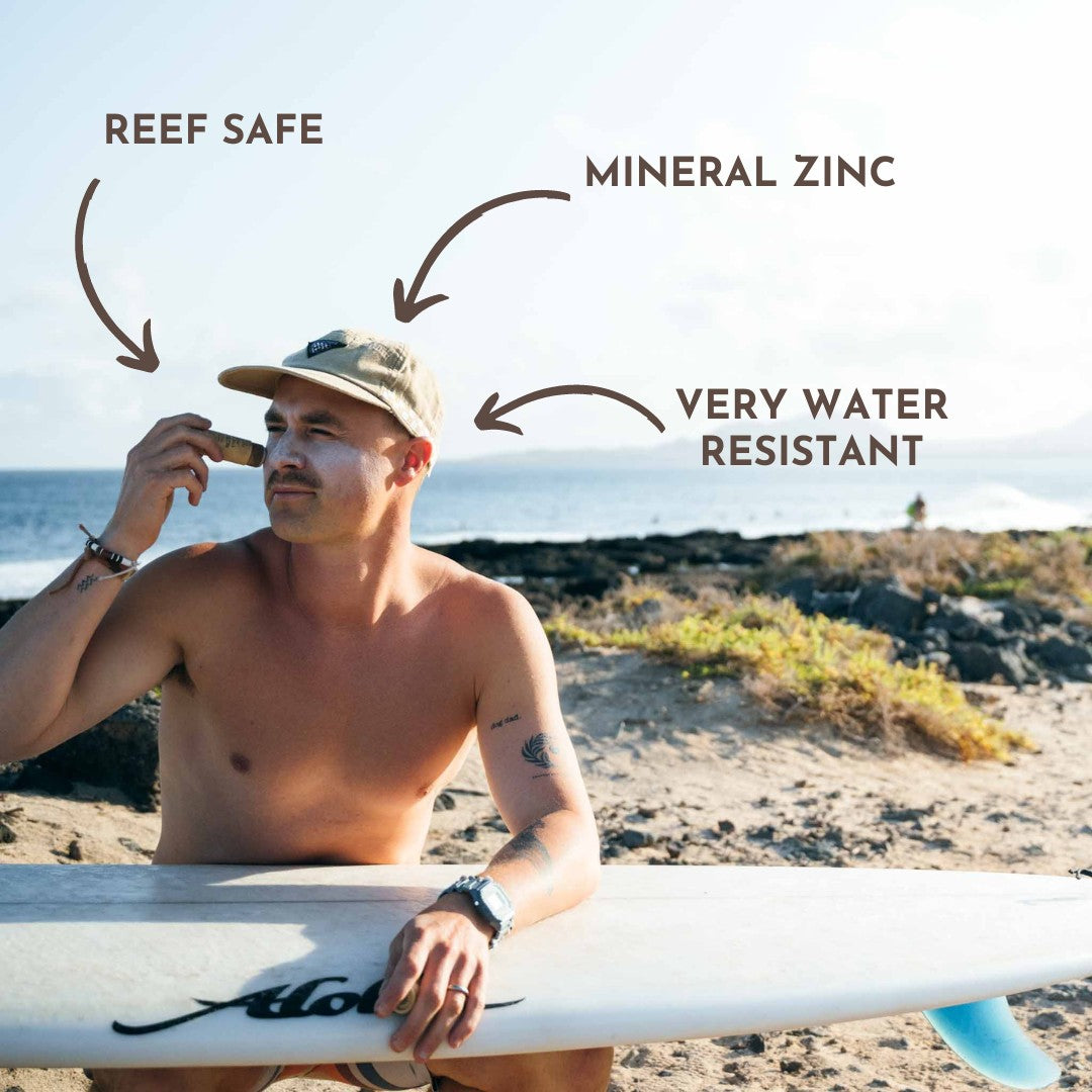 Surfista aplicándose protector solar de zinc en la cara antes de entrar al agua.