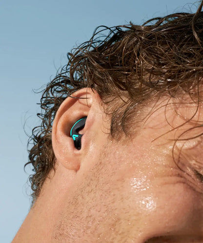 Surfista con el pelo mojado llevando los tapones WaterSafe Pro puestos